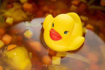 Yellow rubber duck swimming on the soup, duck stock, broth, Vegetable soup