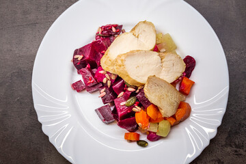 Chicken breast with salad of roasted beets, radishes, carrots and celery with seeds. Healthy dinner