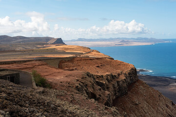 View of the steep cliffs of the profile of the island of Lanzarote next to the blue sea, seen from...