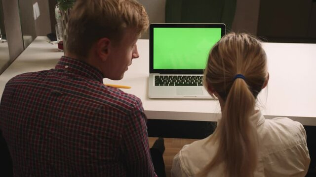 Back view: happy excited couple man and woman using laptop with green screen chromakey at home, happy couple have video call chatting received good news.