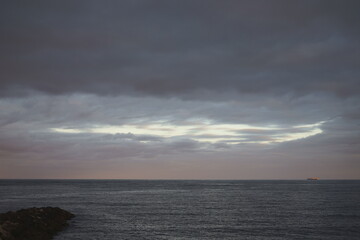 PAISAJE OSCURO MARINO. NUBES OSCURAS TAPANDO EL CIELO AZUL SOBRE EL MAR. ANUNCIANDO TEMPESTAD.