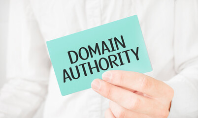 Businessman in white shirt holding a green card with text domain authority