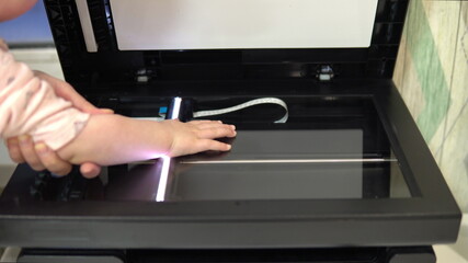 Hand scanning process. The scanner in operation scans a child's hand with the cover open