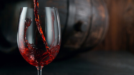 Fototapeta na wymiar Pouring red wine into wine glass