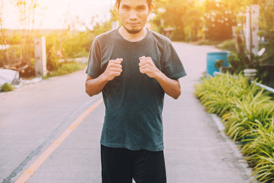 Portrait Of Confidant Male Runner Standing On Street