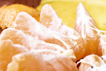tangerine cut into slices close-up on a yellow background