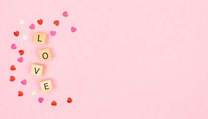 Valentine's Day. LOVE letters on wooden cubes in a pink background. Copy space.