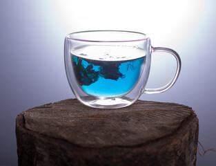 Glass cup with blue tea on white background.