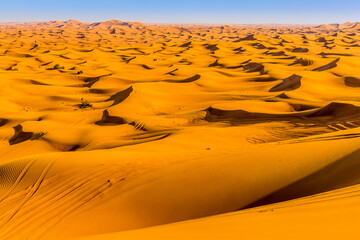 Fototapeta na wymiar Lines of Seif dunes stretch to the horizon in the Arabian red desert at Hatta near Dubai, UAE in springtime