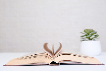 Love books and reading concept, book pages folded into a heart shape with copy space