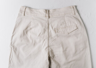 Close up of a back pocket of white cotton trousers