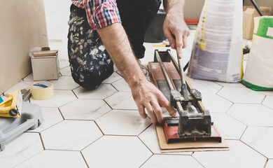 Renovation - Interior finishing worker (tiler or handyman) using manual tile cutter