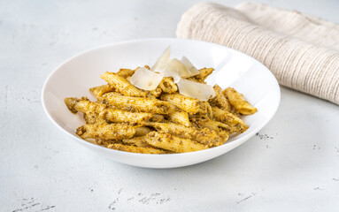 Portion of penne pasta with pesto sauce