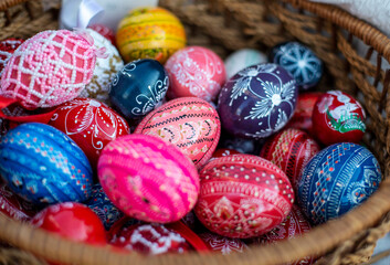 Many colorful decorated easter eggs in wicker basket