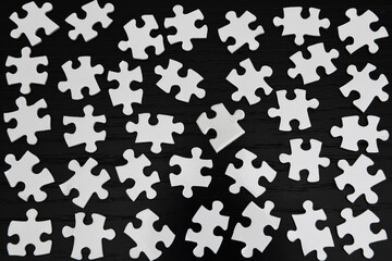 White jigsaw puzzle pieces on a black table