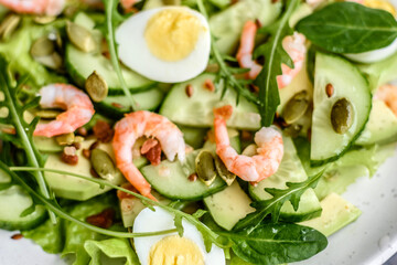 Salad with shrimp, avocado, cucumber, pumpkin seeds and flax seeds with olive oil