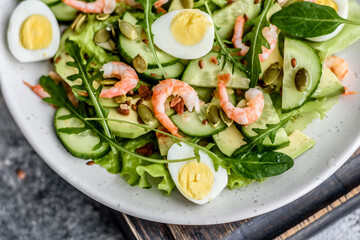 Salad with shrimp, avocado, cucumber, pumpkin seeds and flax seeds with olive oil