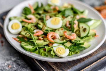 Salad with shrimp, avocado, cucumber, pumpkin seeds and flax seeds with olive oil