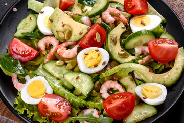 Salad with shrimp, avocado, cucumber, pumpkin seeds and flax seeds with olive oil