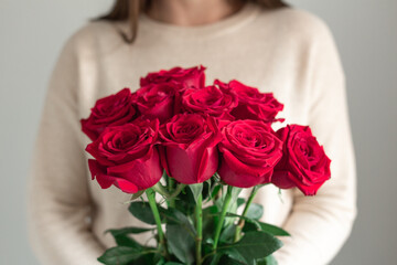 Woman holding fresh blossoming flower bouquet of red roses. Copy space - Image