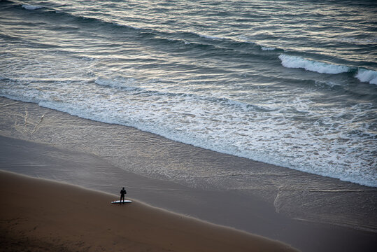 Surfista en la orilla prepar&aacute;ndose para surfear en la orilla de una playa