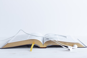 open bible with headphones or earbuds