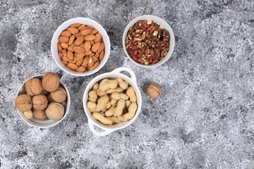 Obraz na płótnie Canvas Assortment of different nuts, the concept of healthy natural food, almonds, pecans, pistachios, cashews, walnuts and pine nuts, high-calorie food with vegetable protein, the basis of diet food