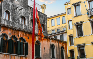 Fototapeta na wymiar The red and yellow flag of Venice flies in a piazza in Venice, Italy.