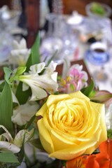 Close-up of n vase of flowers on a dressing table with a breakfast in the background