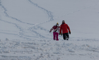 Una pareja pasea por un paisaje nevado en un puerto de montaña