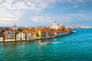 A Venice, Italy water taxi cruises the grand canal with the dome of Santa Maria Della Salute...