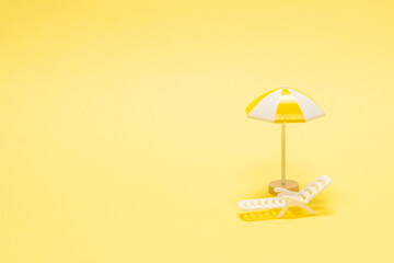 Sun lounger and yellow umbrella on a yellow background.