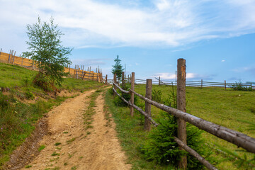 Fototapeta na wymiar Mountain hills pure nature rural landscape. Fence from wooden logs