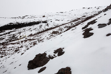 landscape of a mountain with rocks, snow and a cloudy sky, slope of a rocky snowy with snowfall