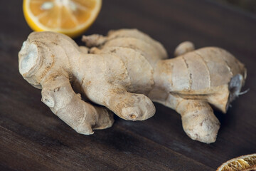 Fototapeta premium Organic ginger root and lemon on a wooden table, close up, macro photography