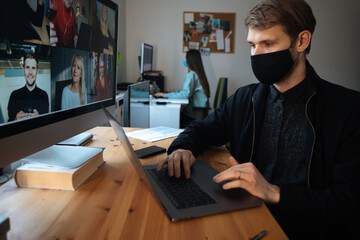 Young man having Zoom video call via a computer in the home office. Stay at home and work from home concept during Coronavirus pandemic.