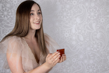 An attractive young woman looking excited and happy as she is being asked to marry her, engagement wedding concept