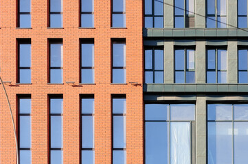 Fototapeta premium Fragment of common building facade with windows reflecting the sky