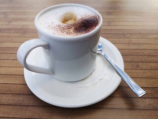 Cappuccino in einer Tasse mit Löffel, Kaffepause, dolce vita
