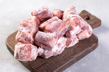 Frozen raw beef bones on a cutting board