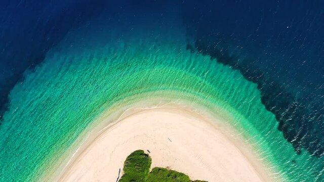 Drone zooming in on Ag Dimitrios Alonissos beach in Greece. The camera facing down, capturing the beautiful beach that is shaped like an arc.