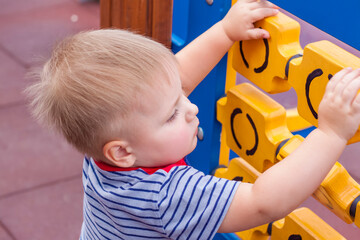 A little boy enthusiastically plays on the playground. Success, creative ideas and sports concepts....