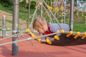 A little boy enthusiastically plays on the playground. Success, creative ideas and sports concepts....