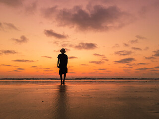 Fototapeta premium man walking on the beach in a sunset