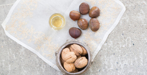 Walnuts, chestnuts and a golden liquor glass on a concrete surface
