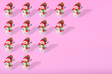 Fototapeta na wymiar Minimal winter pattern made of snowman on light pink background.