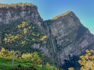 Fototapeta na wymiar Big mountain with a waterfall, sun and trees