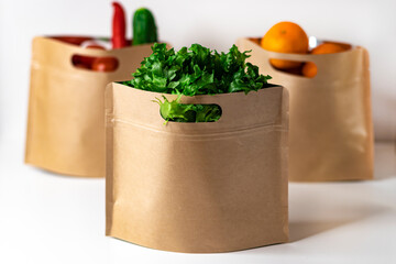 Reusable zippered paper bags for storing food with fresh vegetables, salad and fruits. Plastic-free packaging, zero west concept.