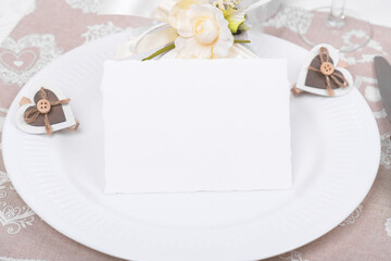 Romantic table setting with empty white card mockup and eco-friendly linen packaging gift with wooden heart decoration. Eco friendly zero waste present set for Valentines Day, Birthday or Mothers Day