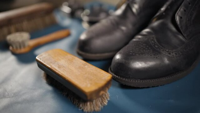 VERY cloes view of used old black classic shoes with horsehair brushes getting ready for cleaning and repairing